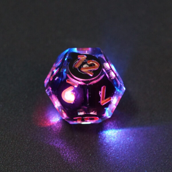 Lit Clear D12 with a rainbow of colors across each face. Clear colorway is fully transparent resin allowing internal circuit board to be visible. The numbers or symbols are painted metallic copper.